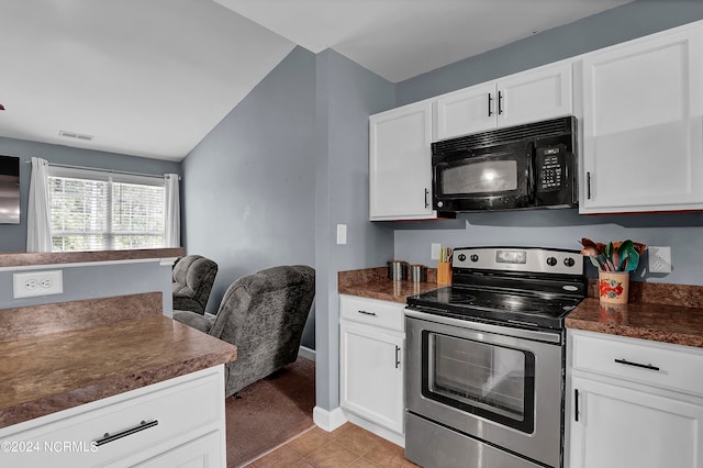 kitchen featuring vaulted ceiling, stainless steel electric range oven, light tile patterned floors, and white cabinetry