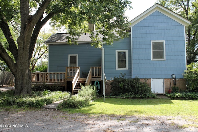 back of property with a wooden deck and a yard