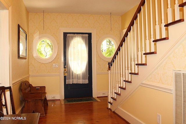 entryway with an inviting chandelier and dark hardwood / wood-style flooring