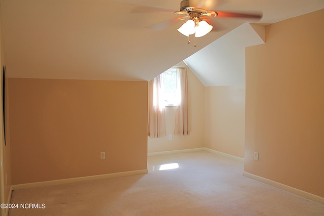 additional living space featuring lofted ceiling, light carpet, and ceiling fan