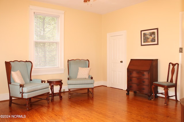 living area featuring hardwood / wood-style floors and ceiling fan