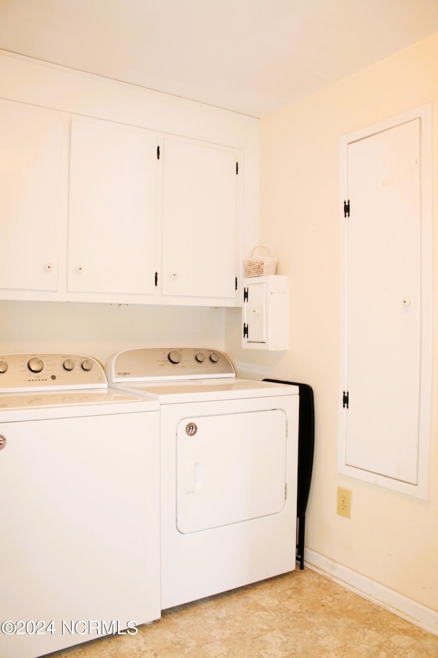 washroom with cabinets, electric panel, and separate washer and dryer