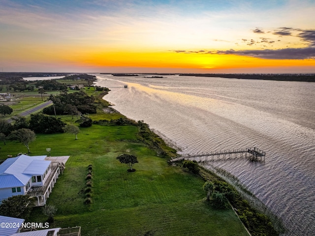 aerial view at dusk featuring a water view