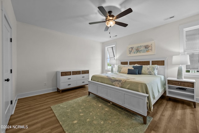 bedroom with dark hardwood / wood-style flooring and ceiling fan