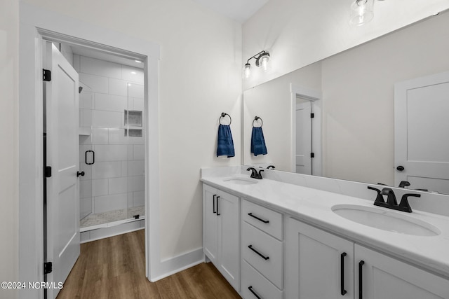 bathroom with wood-type flooring, walk in shower, and vanity