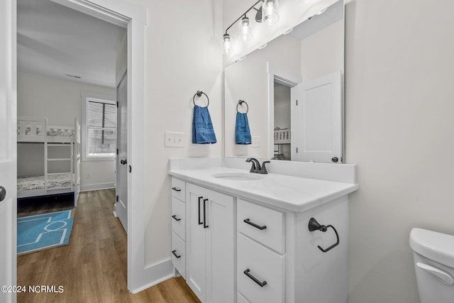 bathroom with hardwood / wood-style floors, vanity, and toilet