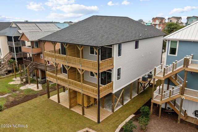 back of property with a lawn, cooling unit, a balcony, and a patio area