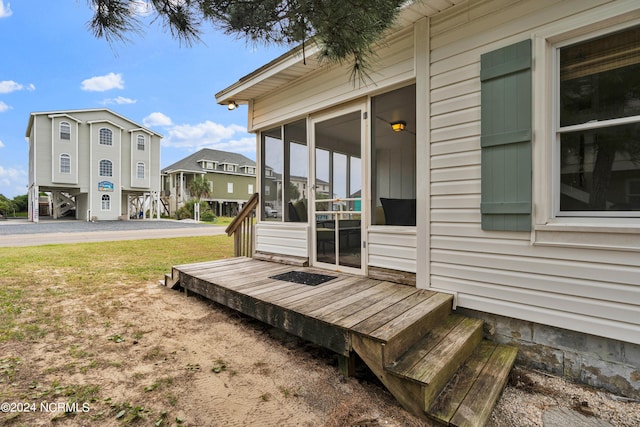 wooden deck featuring a yard and a sunroom