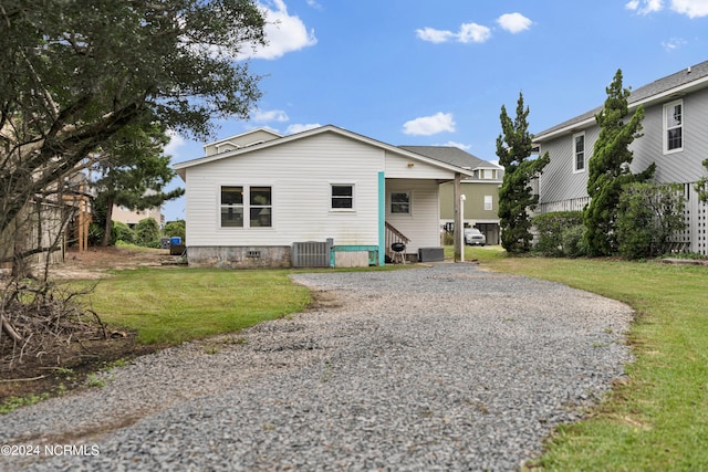 back of house with cooling unit and a lawn