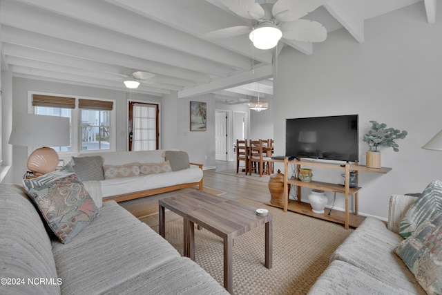 living room with ceiling fan, beamed ceiling, and wood-type flooring