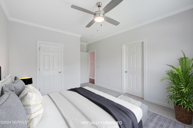 carpeted bedroom with ornamental molding and ceiling fan