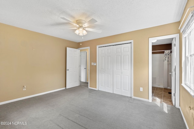 unfurnished bedroom with carpet, ceiling fan, and a textured ceiling