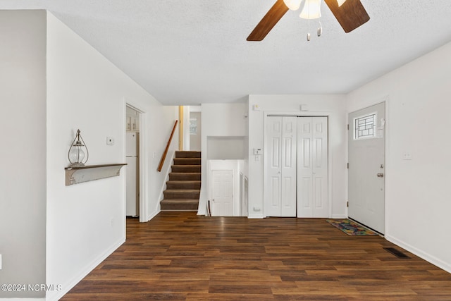 foyer with ceiling fan, a textured ceiling, and dark hardwood / wood-style flooring