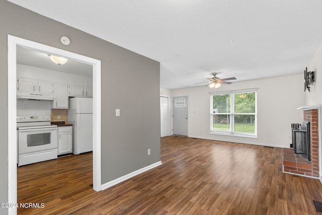 unfurnished living room with dark hardwood / wood-style floors, ceiling fan, and a brick fireplace