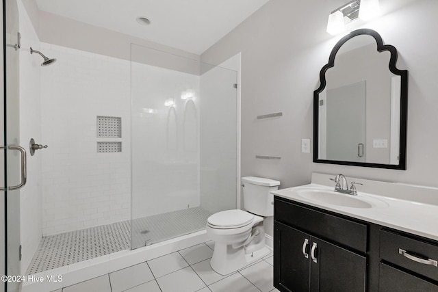 bathroom with toilet, vanity, tile patterned floors, and walk in shower