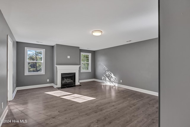 unfurnished living room with dark hardwood / wood-style flooring