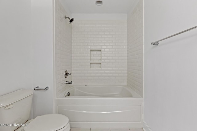 bathroom featuring tile patterned flooring, tiled shower / bath combo, and toilet