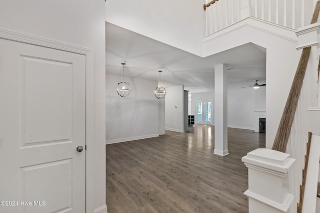 interior space with a towering ceiling and dark wood-type flooring