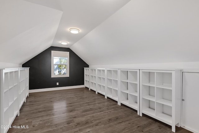 bonus room with dark wood-type flooring and vaulted ceiling