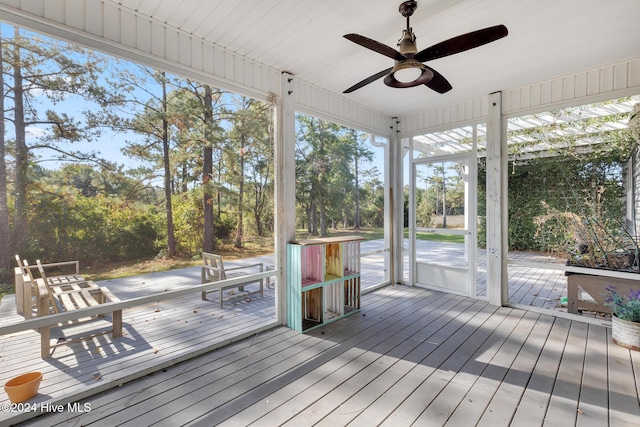 unfurnished sunroom featuring ceiling fan