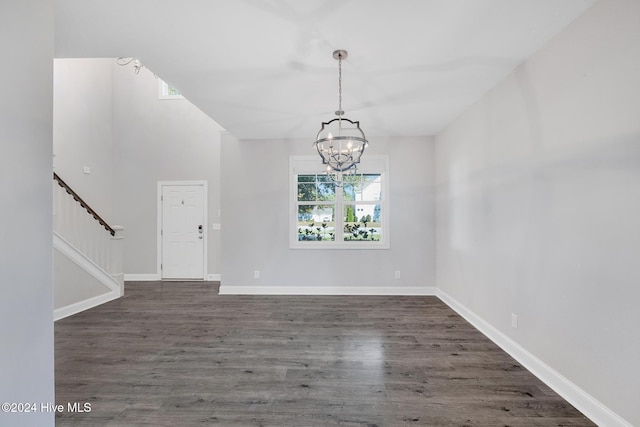 interior space featuring dark hardwood / wood-style floors and an inviting chandelier