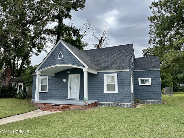 1118 W Main St, Belhaven, NC 27810 - view of front of home with covered porch, a front lawn, and roof with shingles
