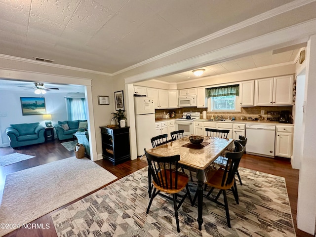 dining area featuring sink, ceiling fan, crown molding, and dark hardwood / wood-style flooring