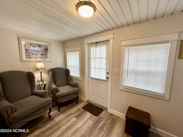 living area with light hardwood / wood-style flooring and wooden ceiling