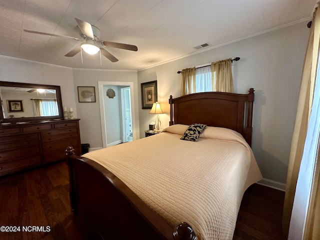 bedroom with ornamental molding, dark wood-type flooring, and ceiling fan