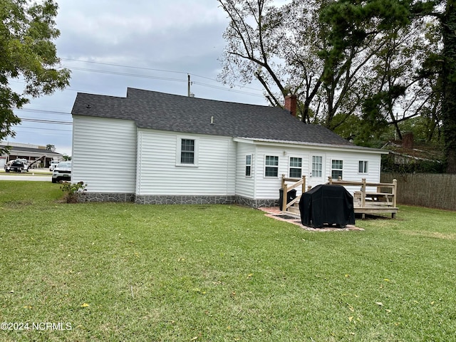 back of property featuring a yard and a wooden deck