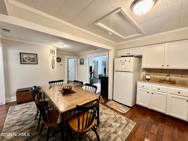 dining area with ornamental molding and dark hardwood / wood-style flooring