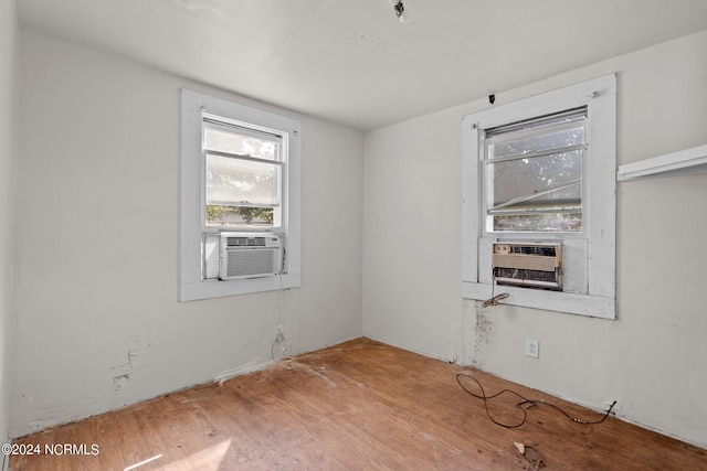 empty room featuring cooling unit, a fireplace, and hardwood / wood-style floors