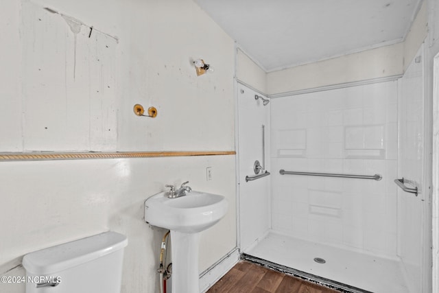 bathroom featuring wood-type flooring, sink, walk in shower, and toilet