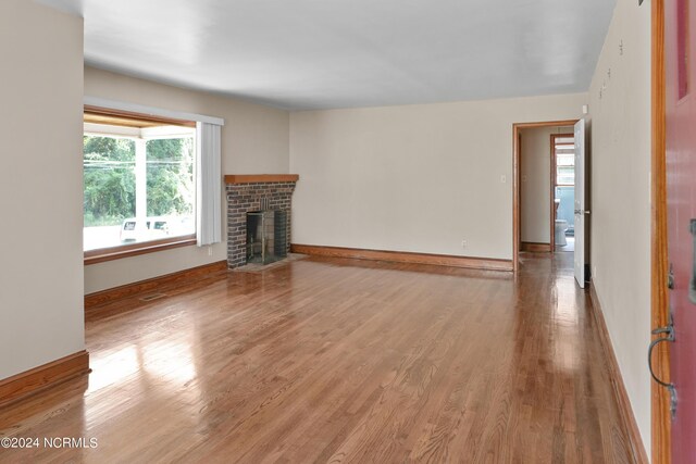 unfurnished living room with a fireplace and hardwood / wood-style floors