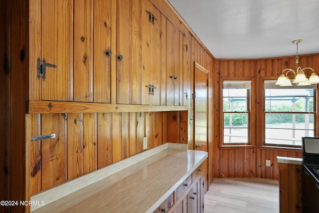 kitchen with wood walls, light hardwood / wood-style flooring, and decorative light fixtures