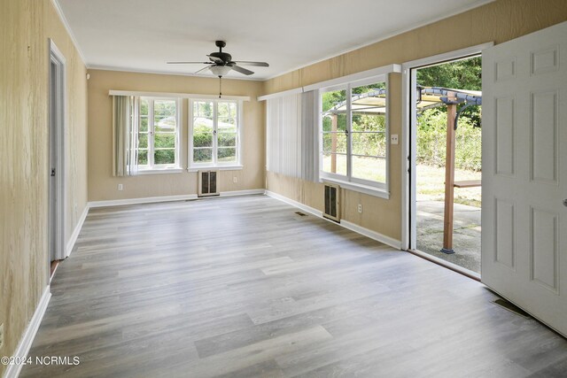 empty room with light hardwood / wood-style floors, ceiling fan, and plenty of natural light