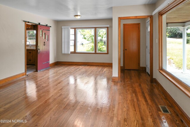 interior space with wood-type flooring and a barn door