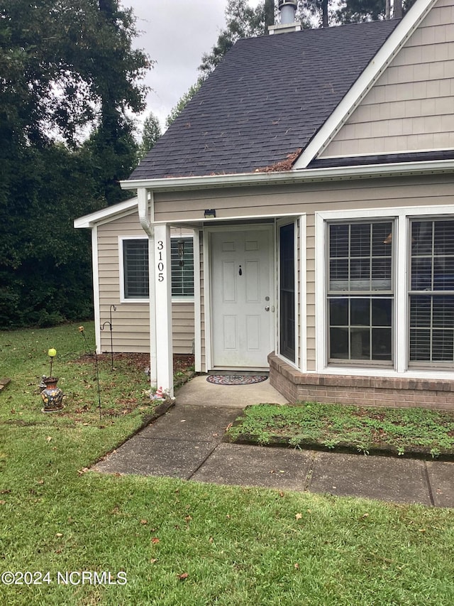 view of exterior entry featuring a yard