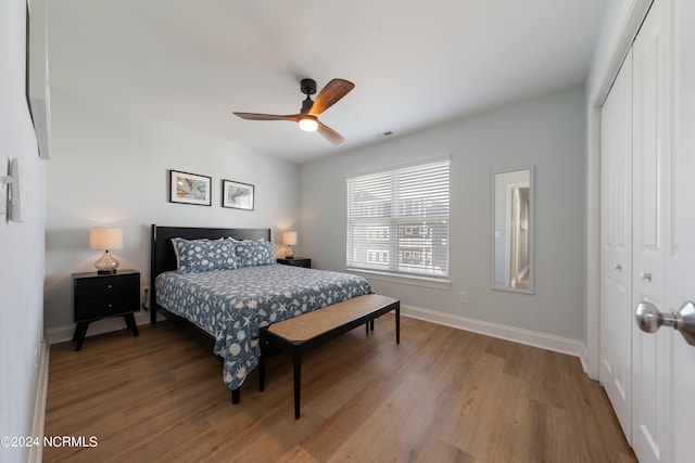 bedroom with wood-type flooring, ceiling fan, and a closet