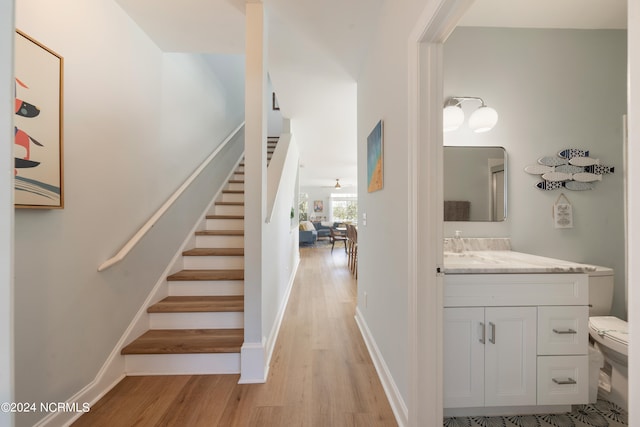 stairs featuring wood-type flooring and ceiling fan