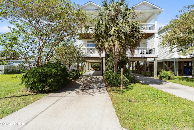 raised beach house featuring a carport and a front yard