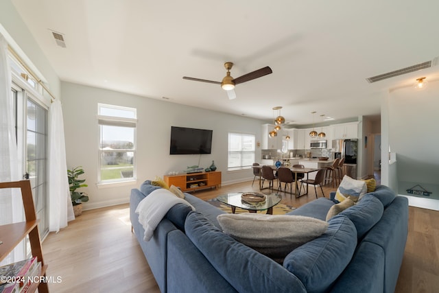 living room with light hardwood / wood-style floors and ceiling fan