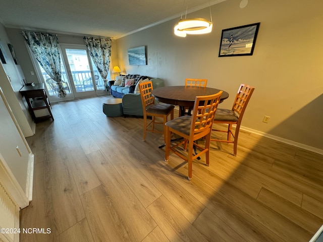 dining space with ornamental molding and hardwood / wood-style flooring