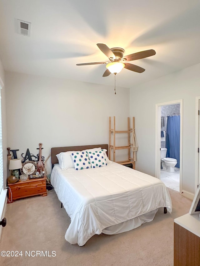 carpeted bedroom with ceiling fan and ensuite bath