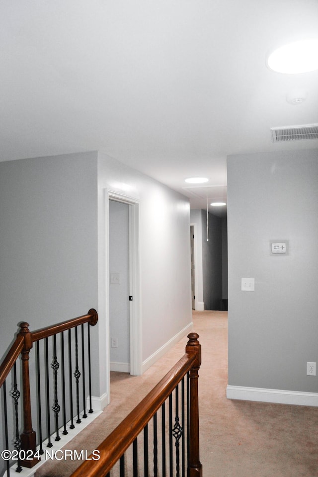 hallway featuring light colored carpet