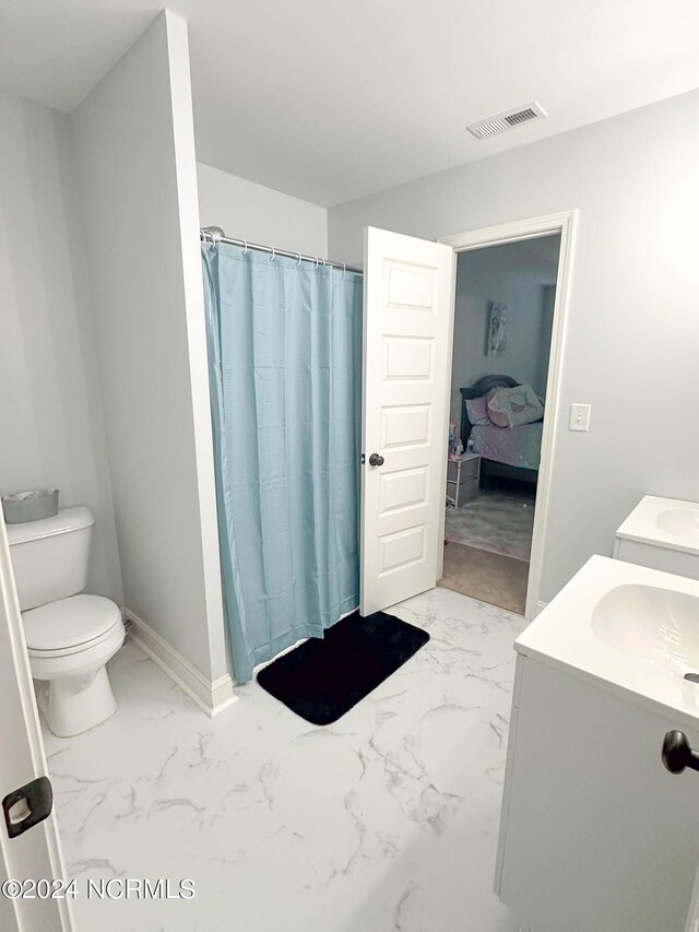 bathroom featuring walk in shower, vanity, and toilet