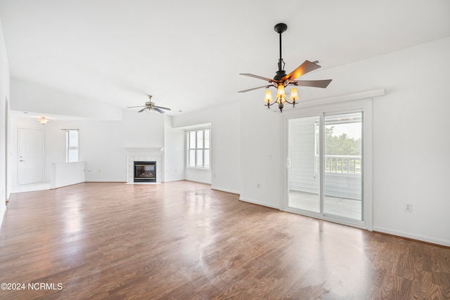 unfurnished living room with ceiling fan, a fireplace, hardwood / wood-style floors, and lofted ceiling