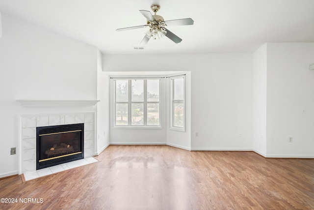 unfurnished living room featuring light hardwood / wood-style flooring, ceiling fan, and a fireplace