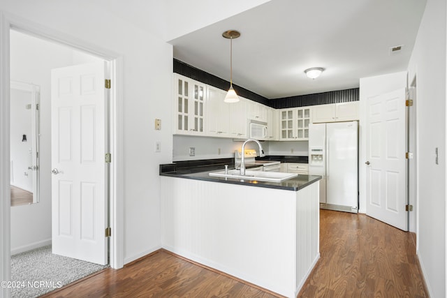 kitchen featuring white appliances, dark hardwood / wood-style flooring, white cabinets, and kitchen peninsula