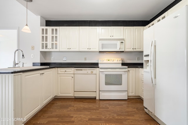 kitchen with hanging light fixtures, white appliances, dark hardwood / wood-style flooring, and sink